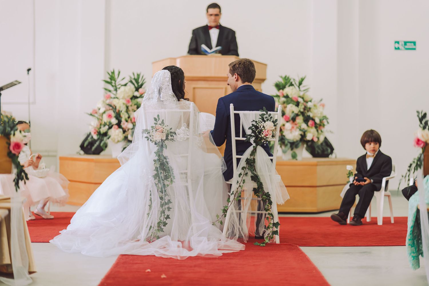Novios sentados frente a frente durante la ceremonia de su boda.