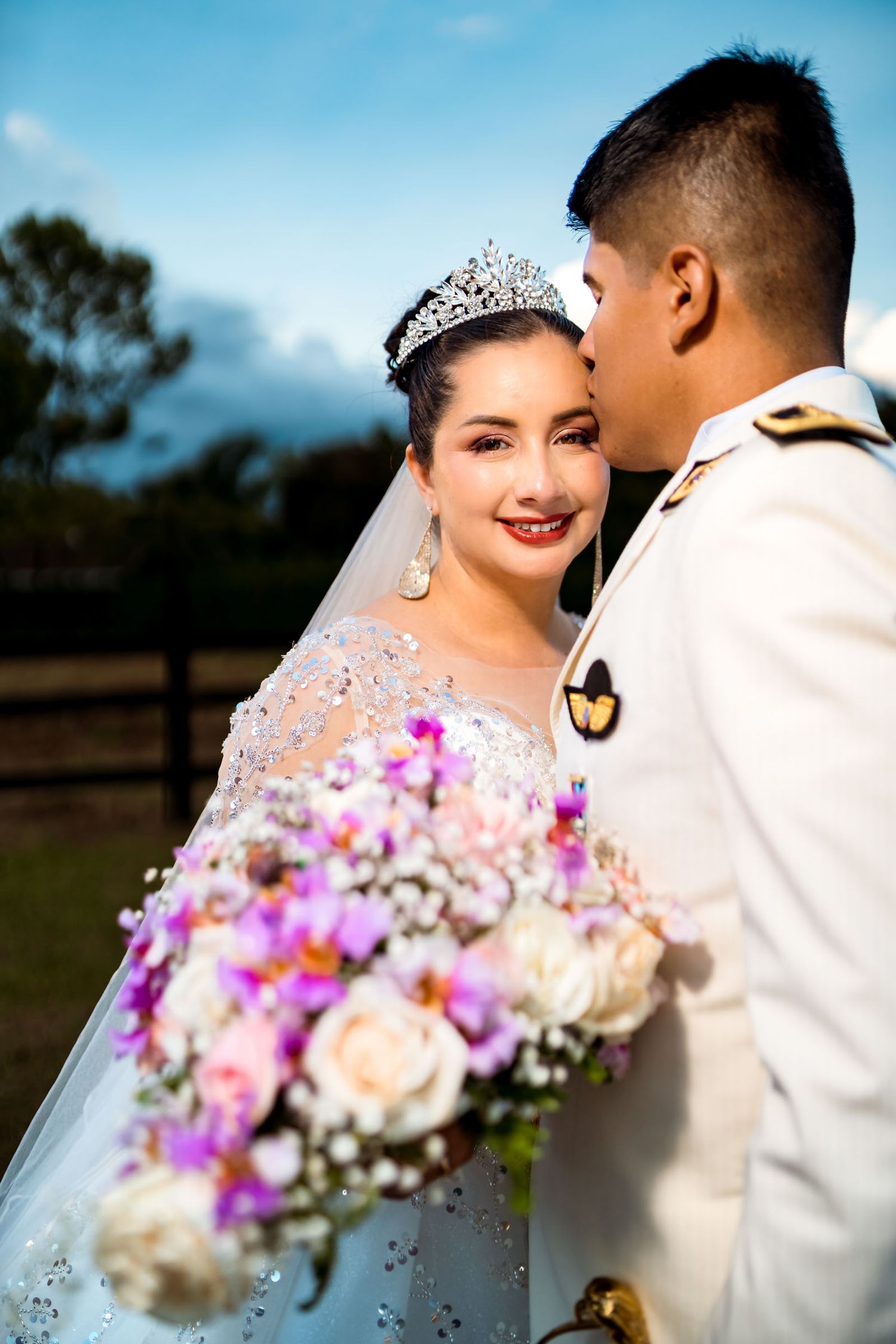 Primer plano del novio besando a la sonriente novia en la mejilla durante su sesión de fotos