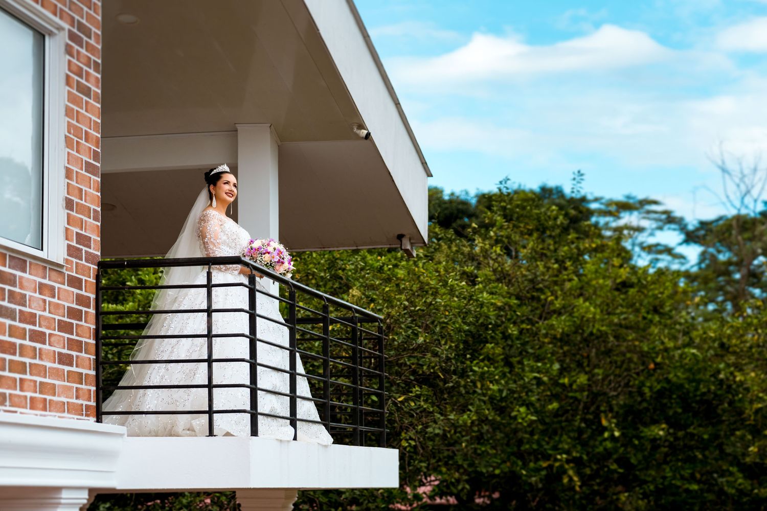 Vista de la novia en el balcón rodeada de árboles y naturaleza antes de su boda en Villavicencio