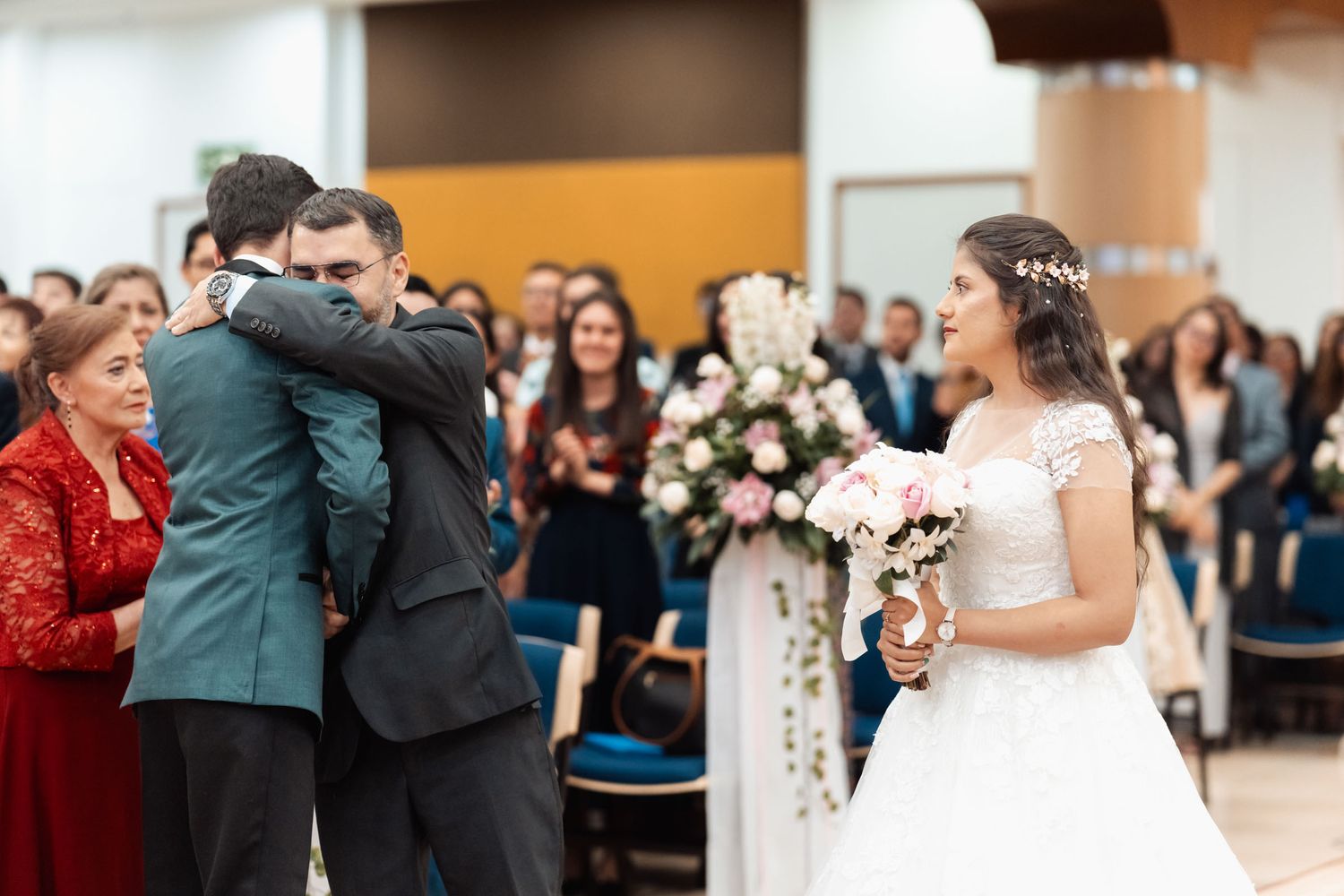 Novio abrazando con emoción a ser querido durante ceremonia de boda