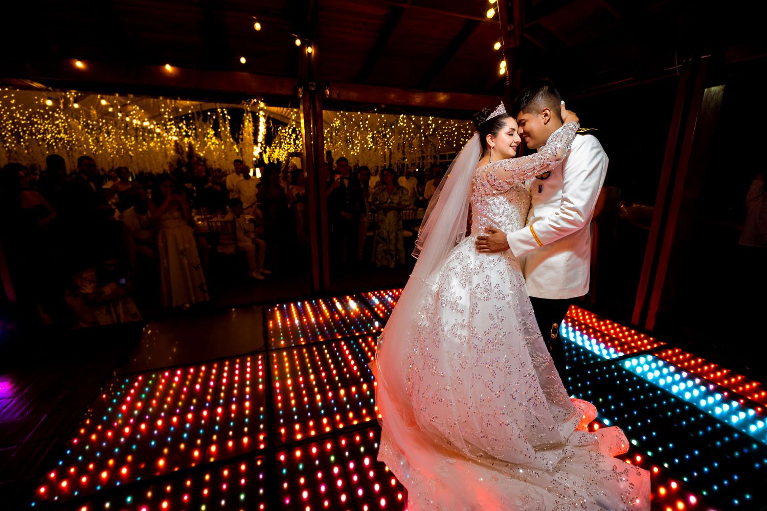 Novios durante su primer baile en una pista de baile con luces de colores