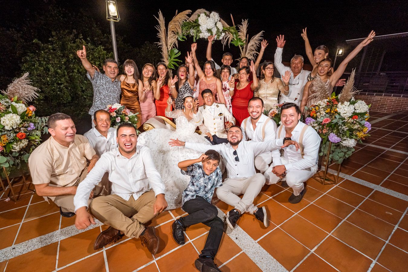 Novios y sus amigos y padrinos de boda posando para una foto grupal durante la celebración