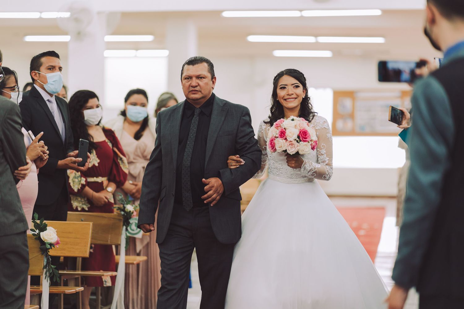 Padre llevando a la novia por el pasillo de la iglesia en su boda en Cajicá.