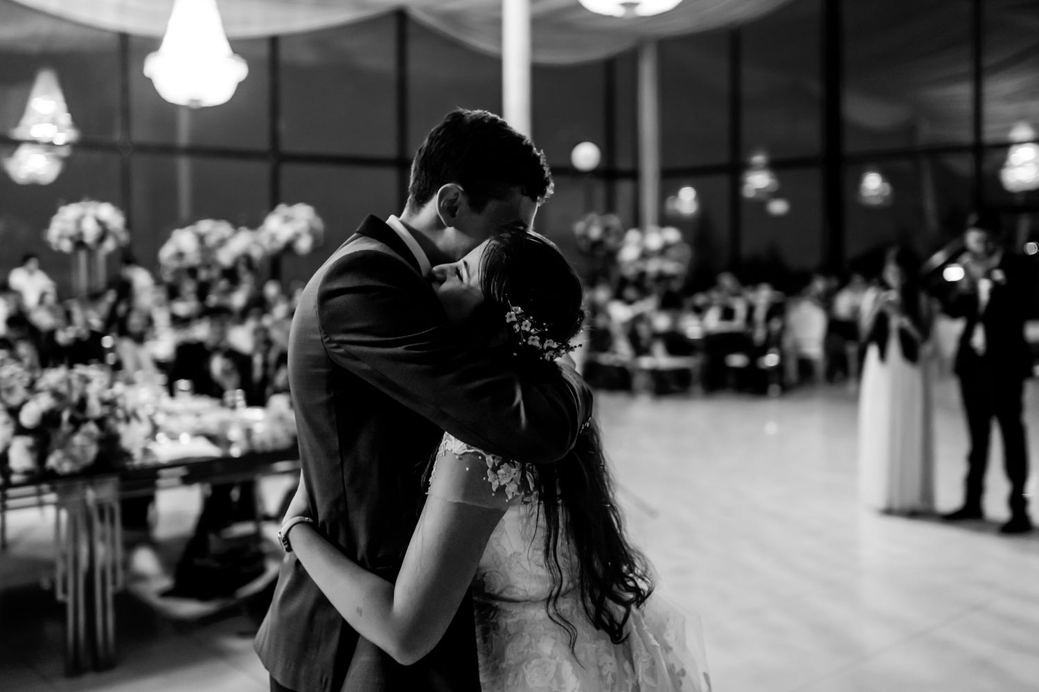 Pareja de novios abrazados en emotivo baile de bodas, foto blanco y negro