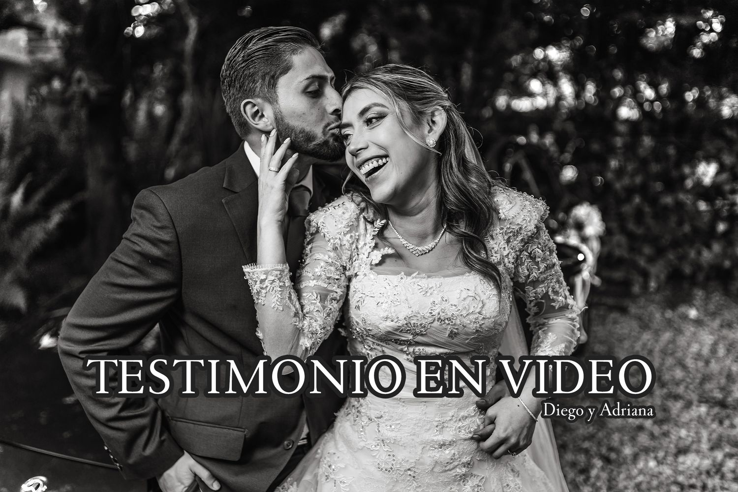Foto de boda en blanco y negro: Novios se besan mientras la novia ríe felizmente, un momento emotivo.