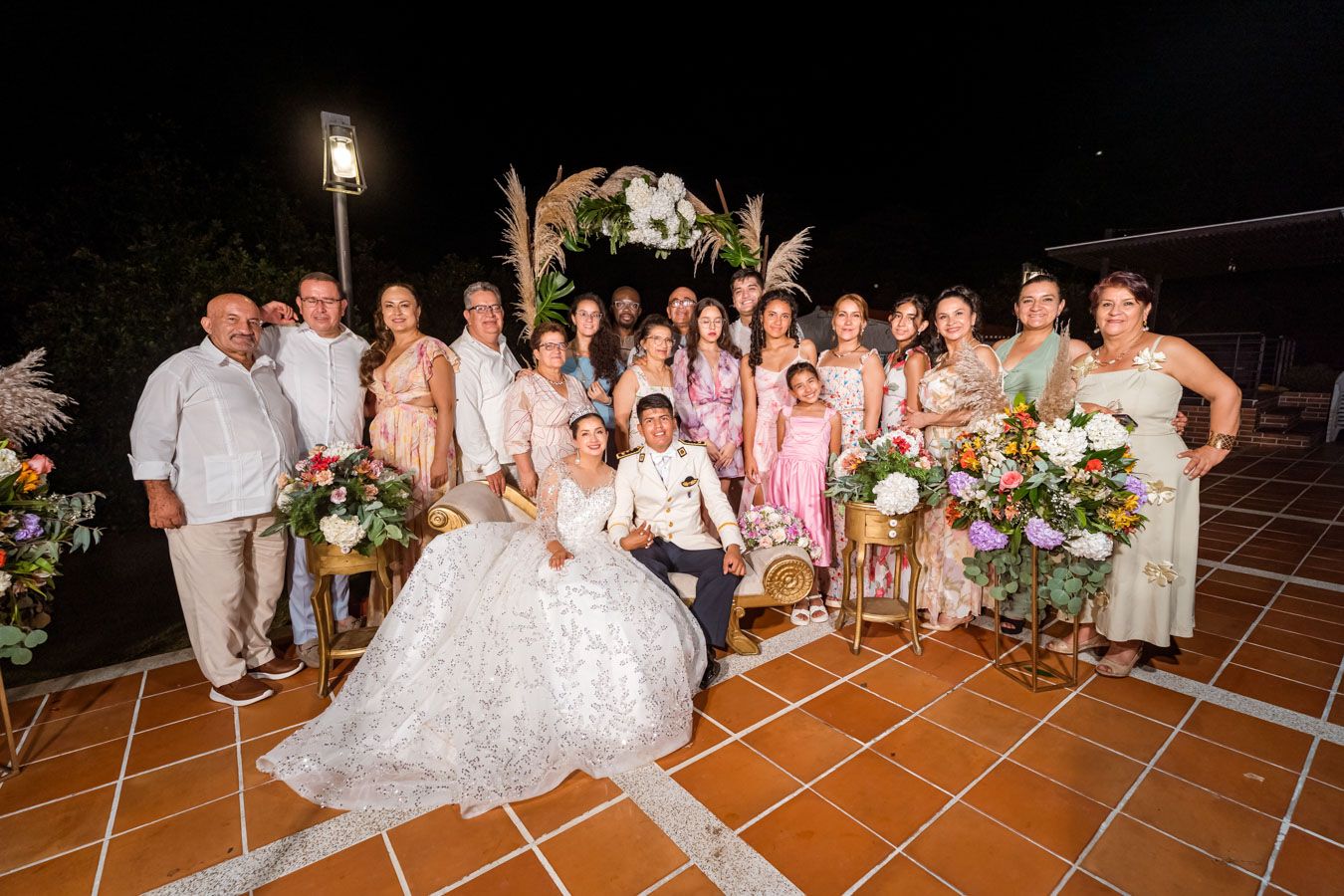 Momento relajado del grupo de invitados sonriendo junto a los recién casados en la fiesta.