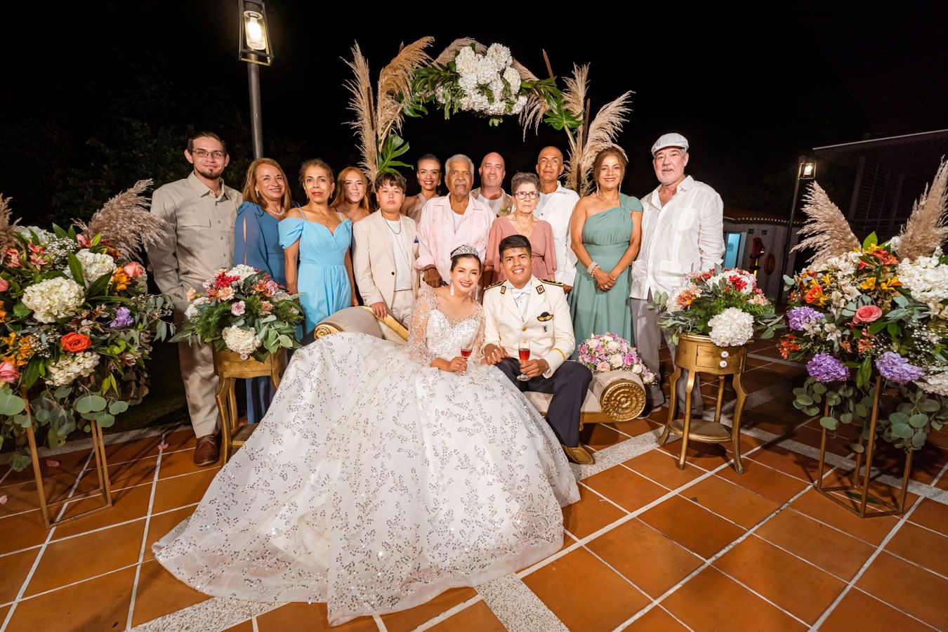 Los novios en el centro de un retrato de grupo formal con sus seres queridos