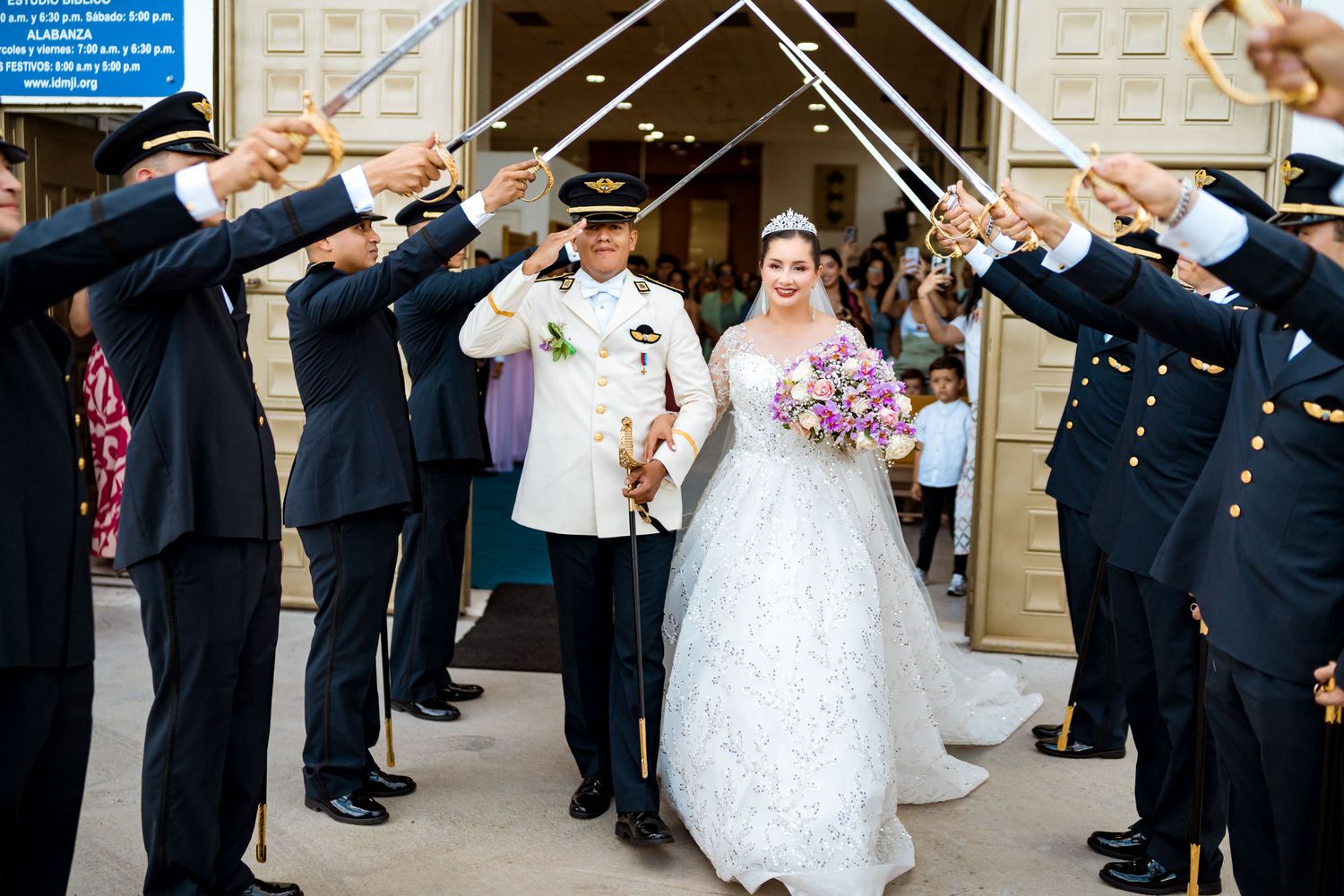 Salida de los recién casados de la ceremonia bajo el tradicional puente de acero de una boda militar