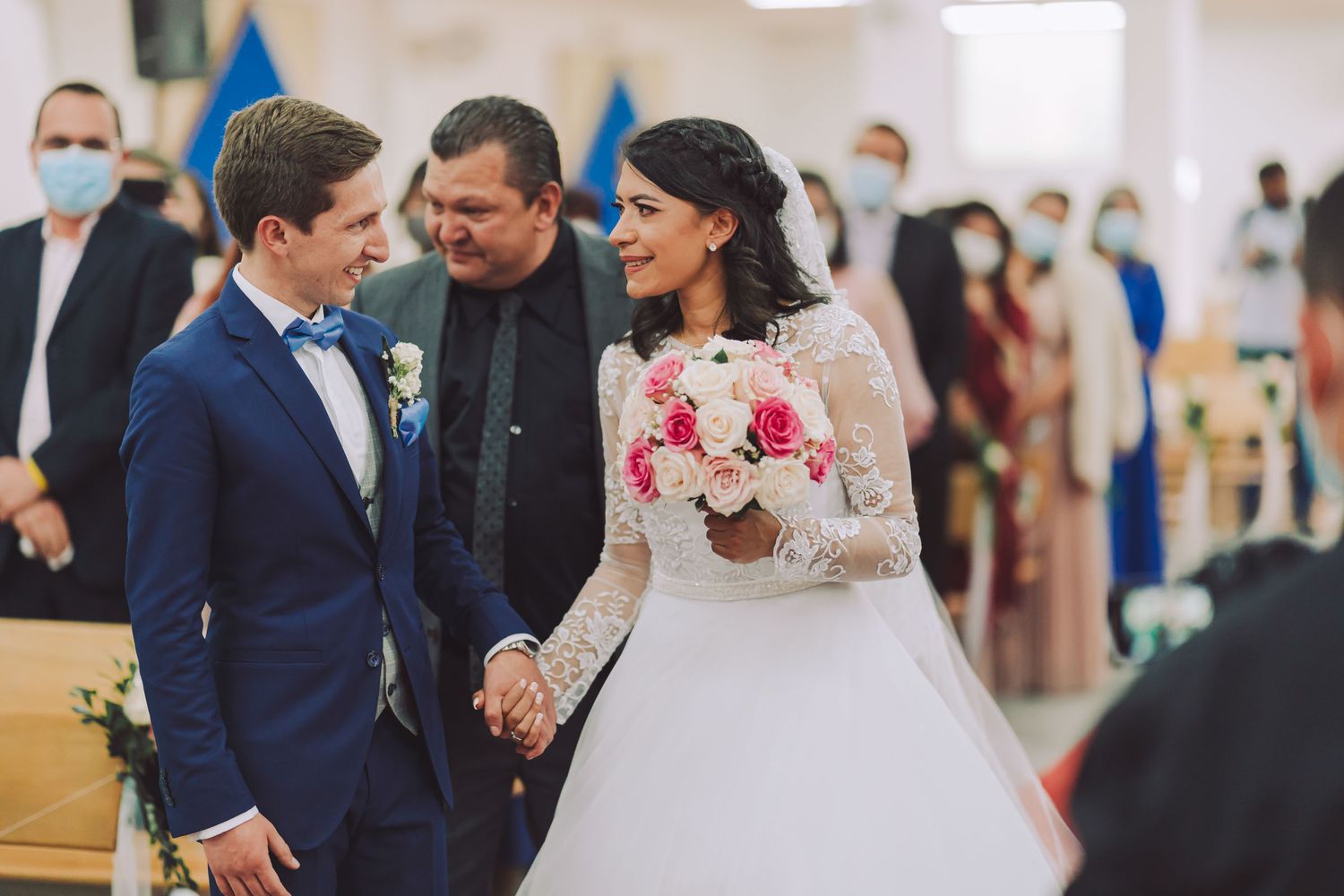 Padre entrega a la novia y novios se toman de la mano sonriendo.
