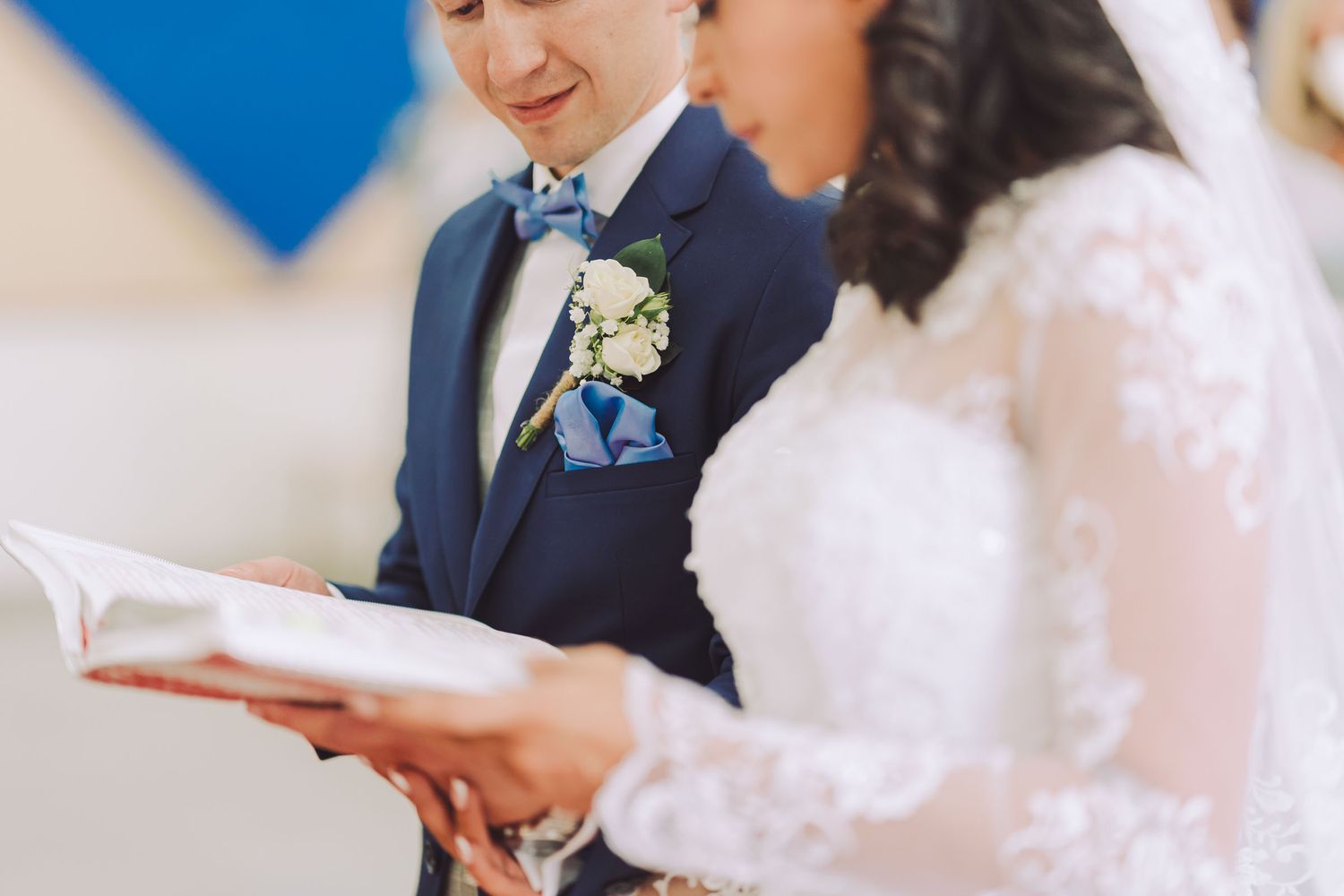 Primer plano de novios leyendo juntos el programa de su ceremonia.