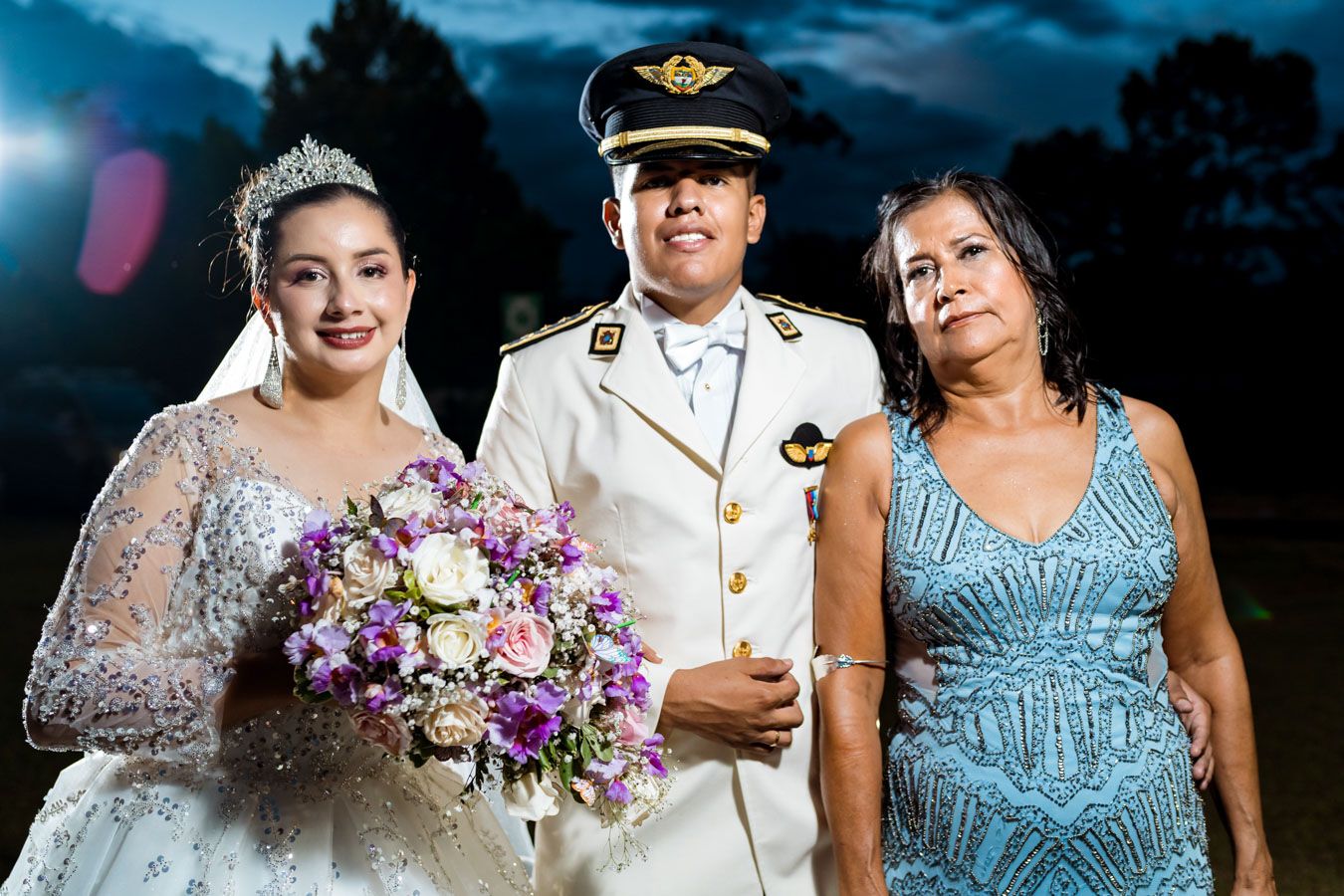 Retrato formal de los novios con una familiar cercana durante su boda