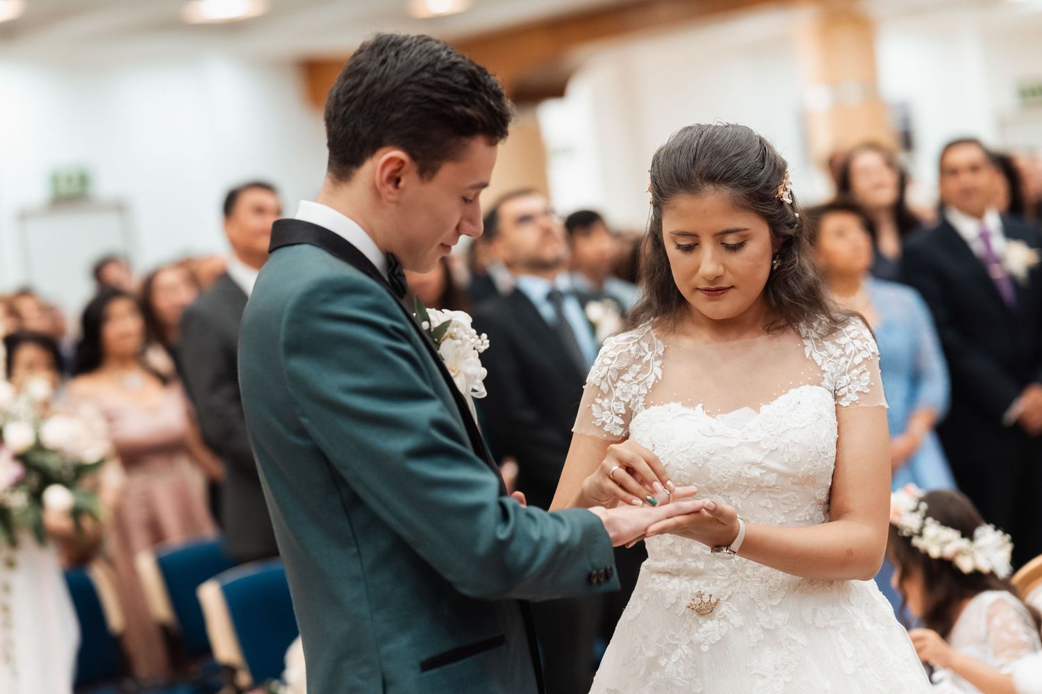 Novio colocando anillo de bodas en dedo de la novia durante ceremonia.