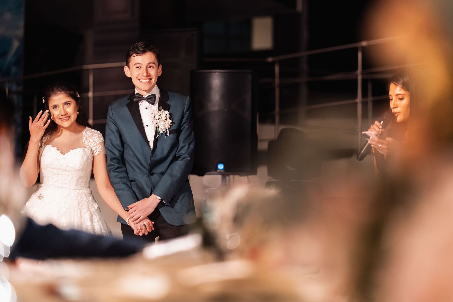 Novios sentados sonriendo durante un momento espontáneo en su recepción.
