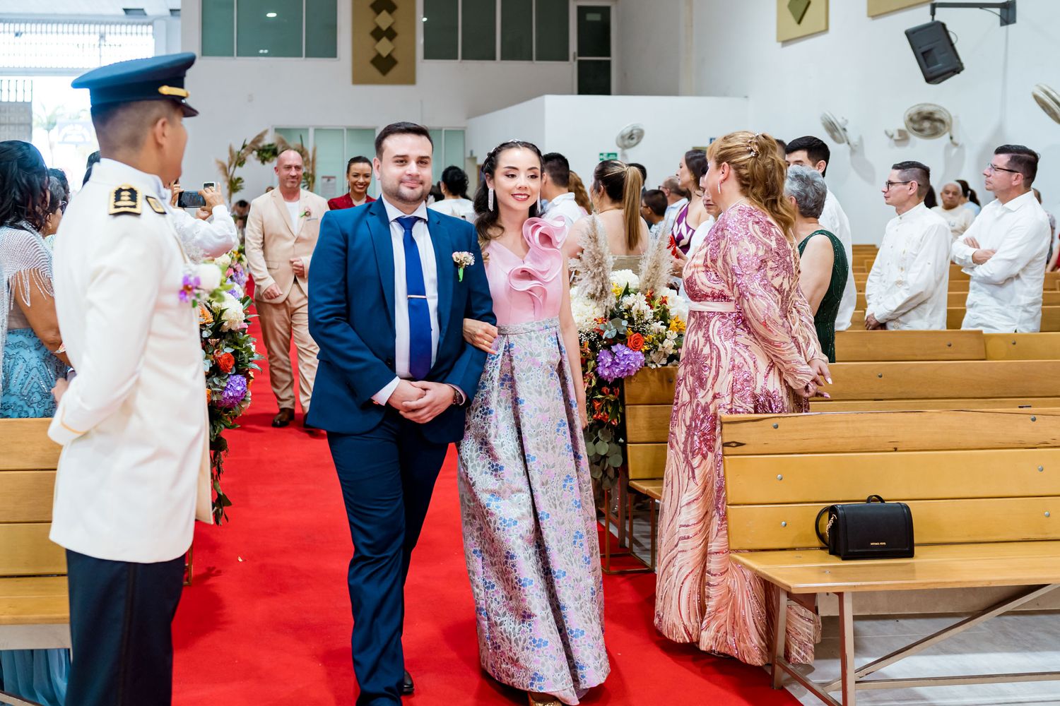 Testigos de los novios caminan por el pasillo de la iglesia al inicio de la ceremonia de boda en Villavicencio