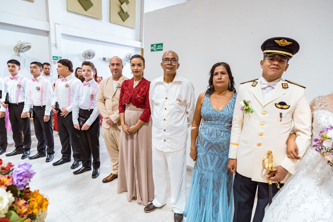 Novio posa orgullosamente con su familia para un retrato formal en el día de su boda