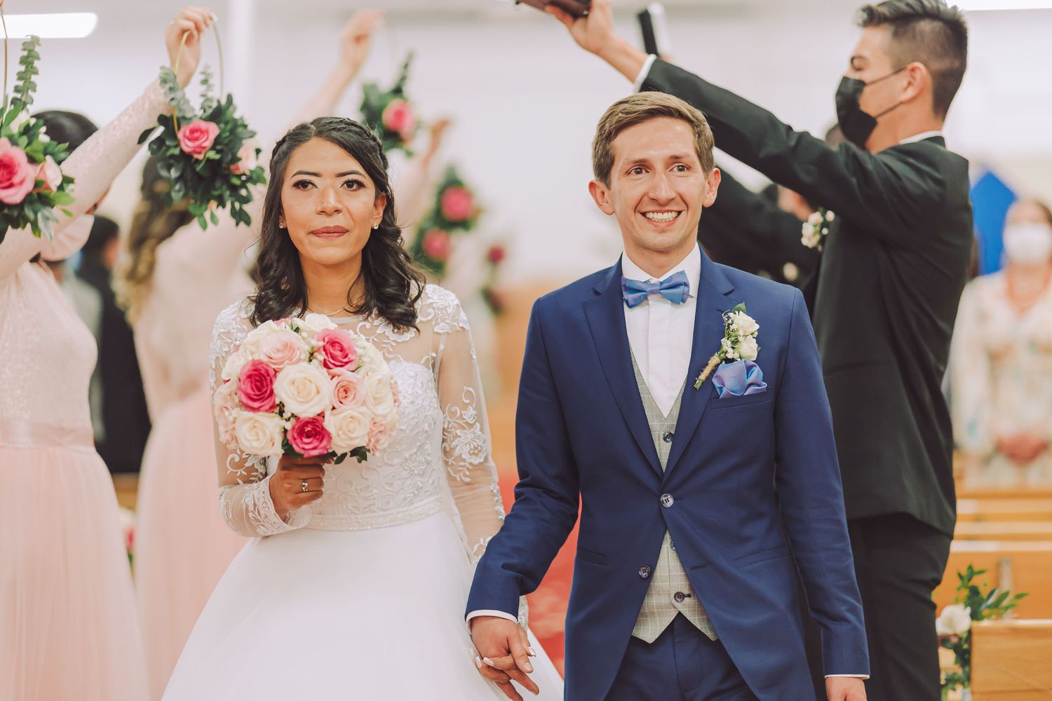 Novios caminando por el pasillo de la iglesia durante la salida de su ceremonia.