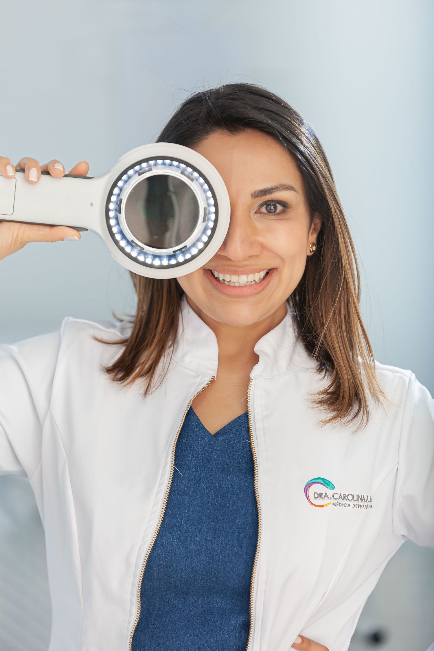 Primer plano en un retrato corporativo de una mujer dermatóloga con un instrumento en la mano.