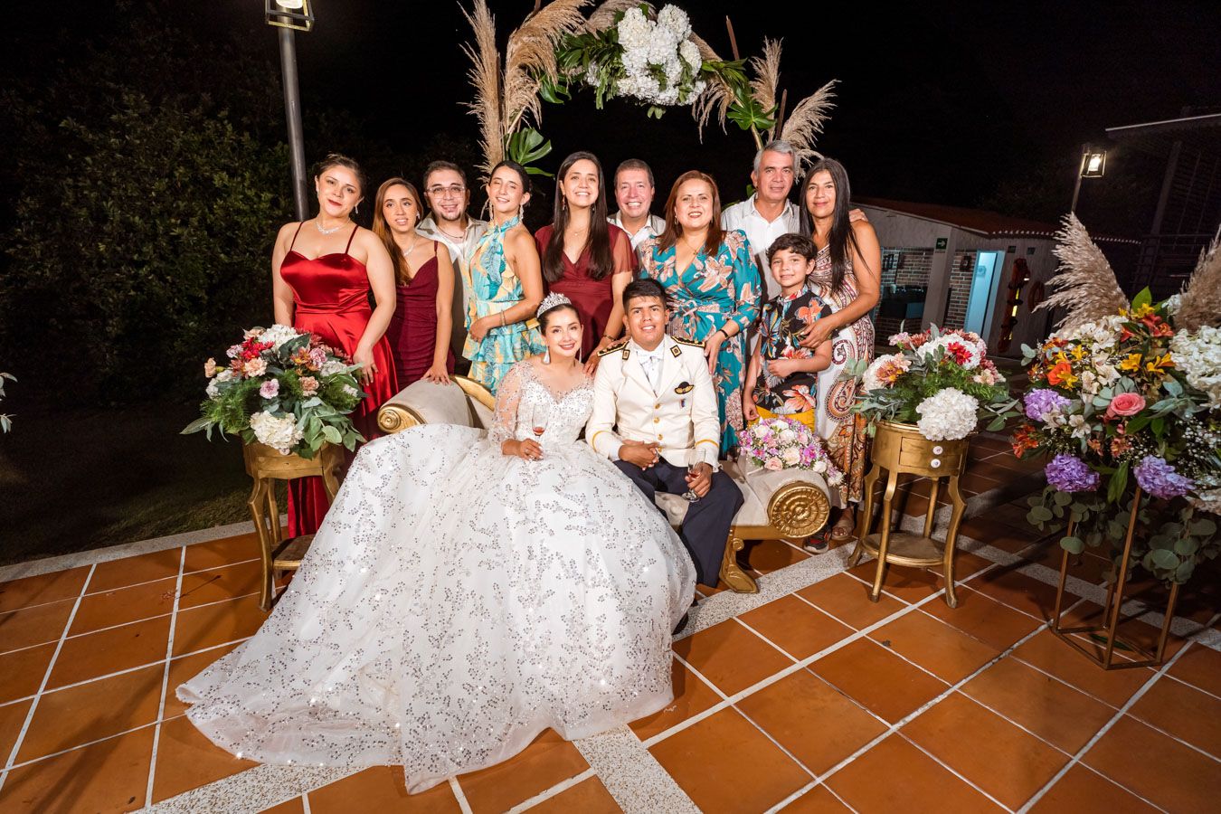 Novios posan sonrientes con su grupo de amigas y damas de honor durante la boda