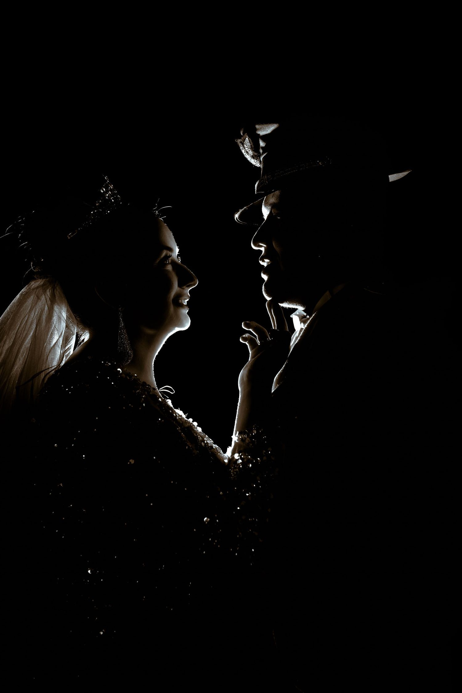 Retrato artístico de los novios con iluminación a contra luz, creando un efecto de claroscuro