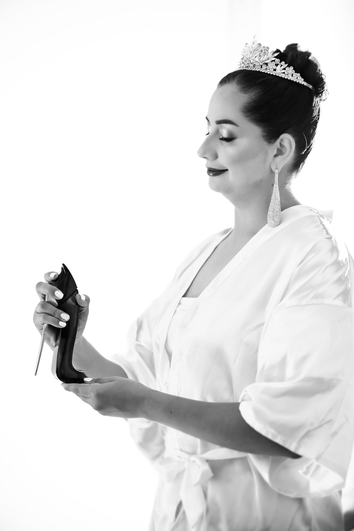 La novia en bata de seda se aplica perfume durante sus preparativos