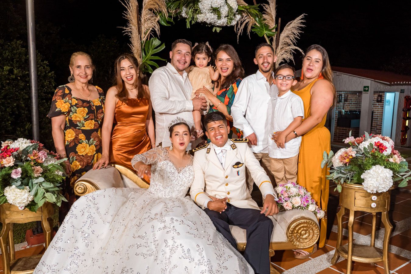 Los recién casados en el centro de un sonriente grupo de amigos y familiares en su boda
