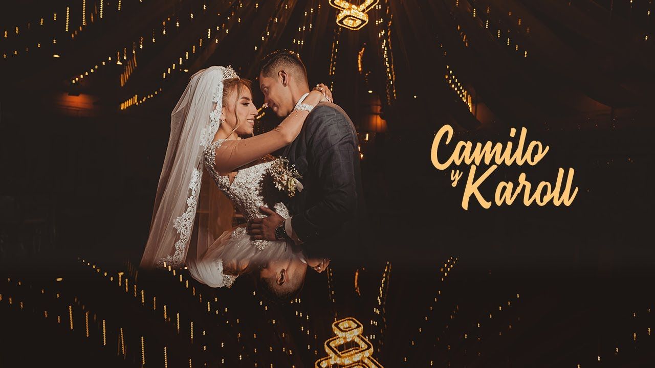 Novios se abrazan en primer plano con su reflejo, rodeados de luces brillantes en la noche. Foto de boda.