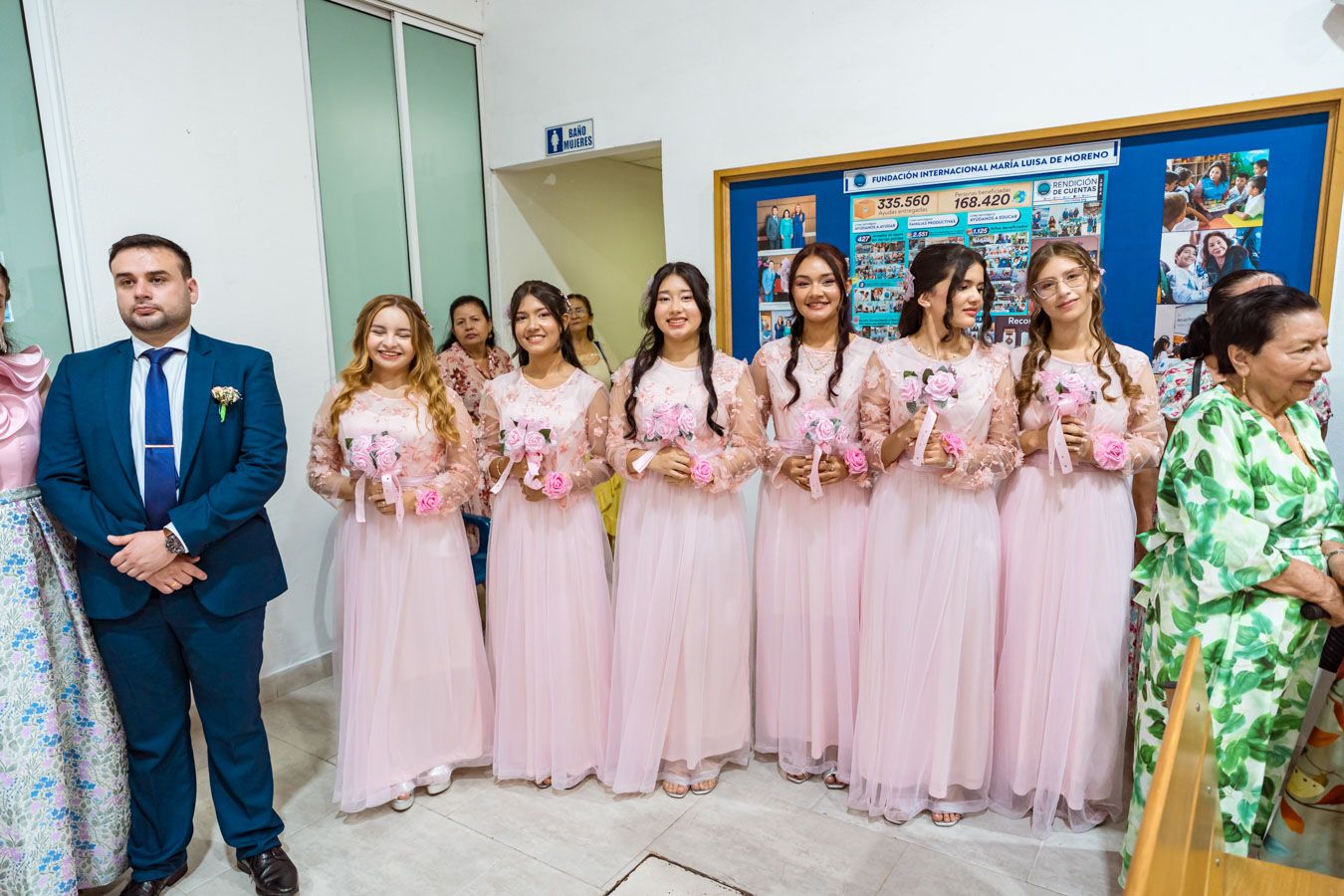 Damas de honor de la boda posan para una foto de grupo con uno de los invitados