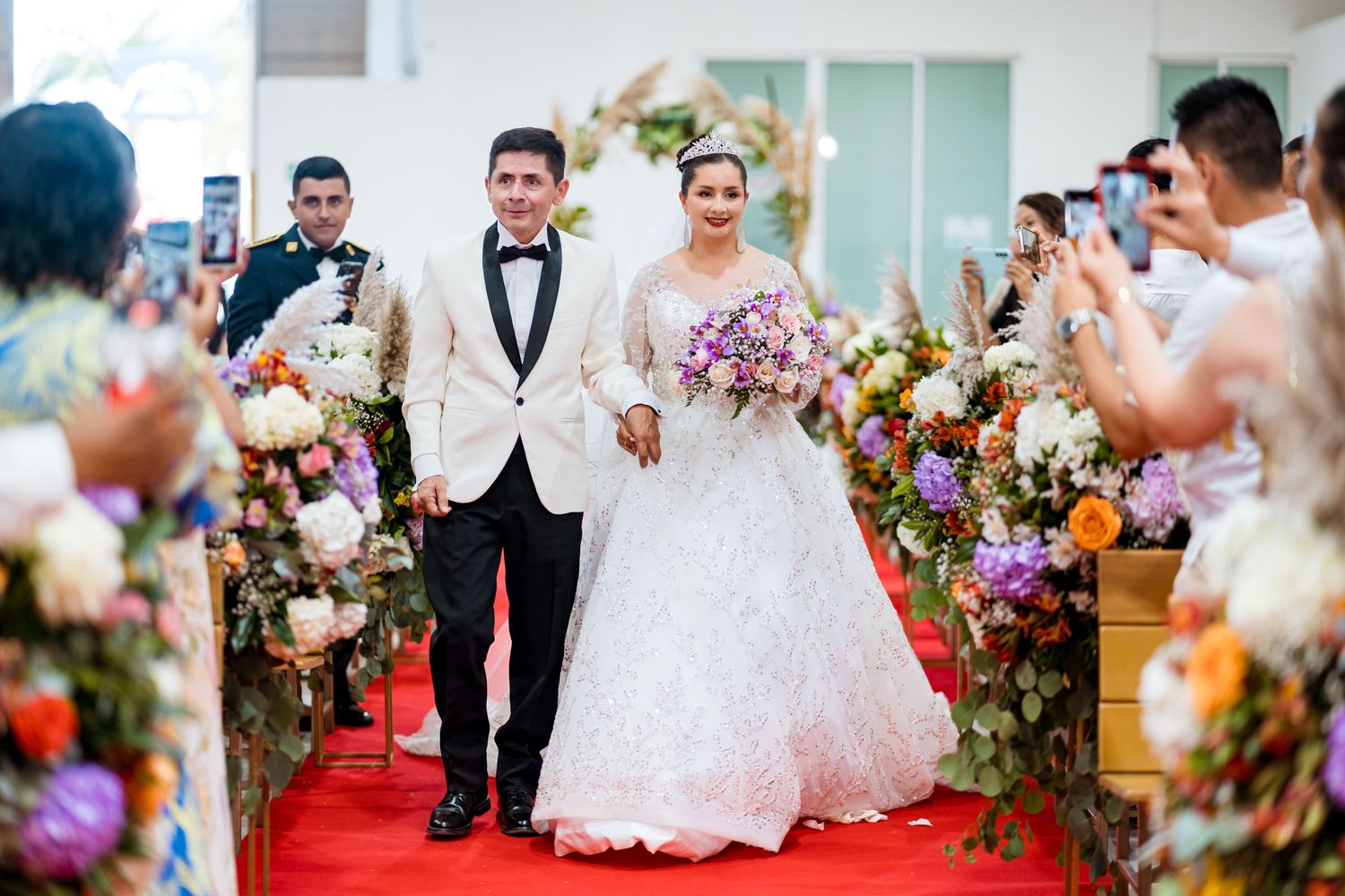 Los recién casados caminan por el pasillo de la iglesia mientras los invitados aplauden