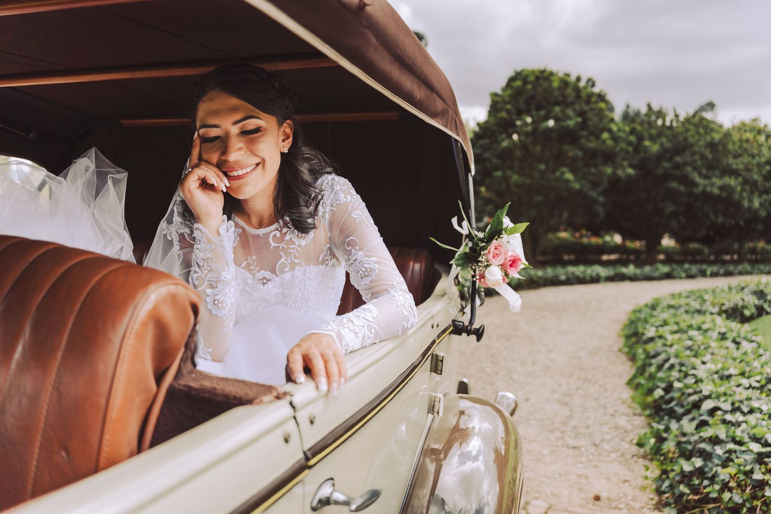 Novia sentada en un coche convertible antiguo durante su sesión de fotos en Cajicá.