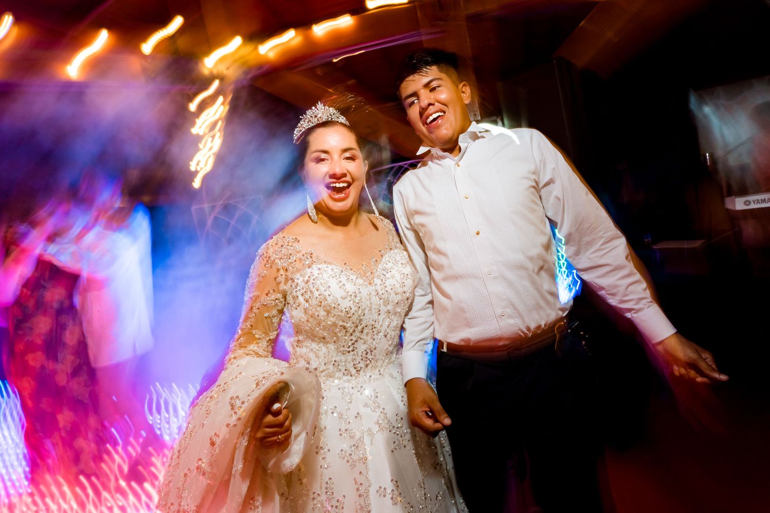 Novia ríe mientras baila con el novio en una foto enérgica de la fiesta de su matrimonio