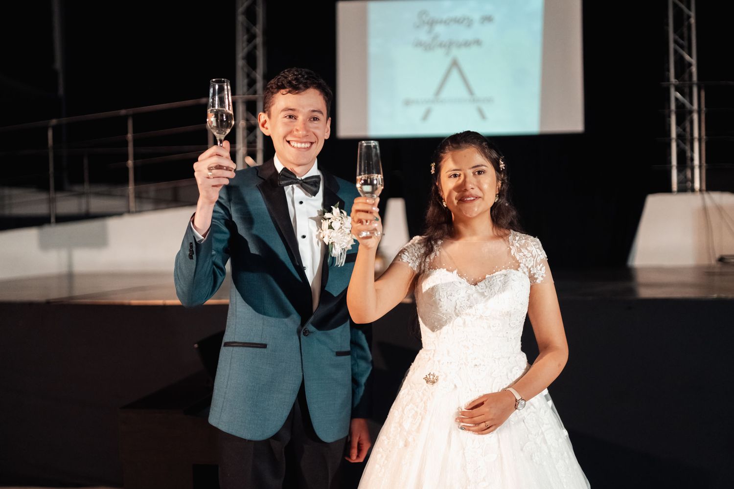 Novios felices brindando con champán durante recepción de boda