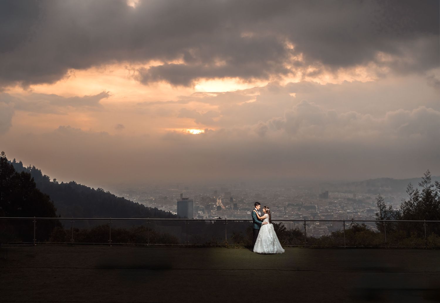 Pareja de novios en silueta admirando el paisaje al atardecer en su boda