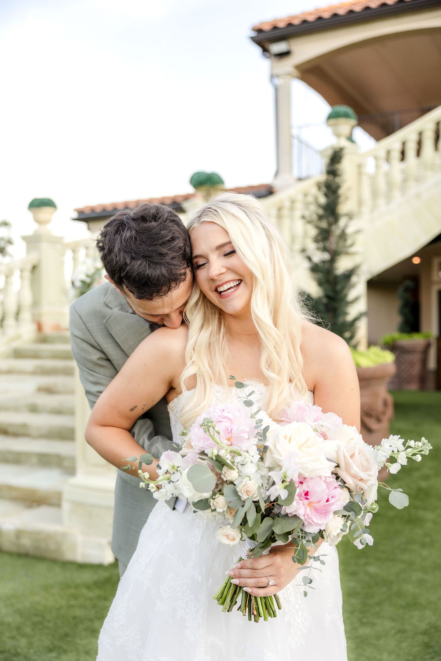 Groom kissing bride's shoulder at D'Vine Grace Vineyard wedding venue in Dallas