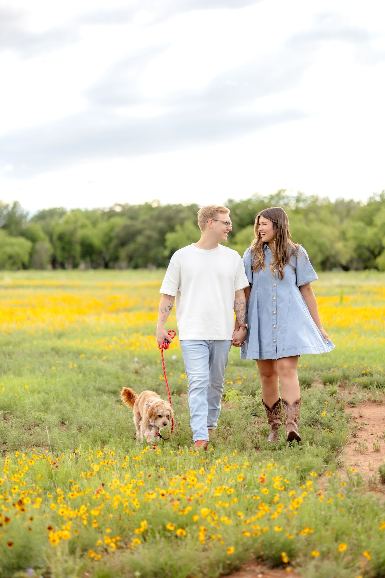 Married couple walking together in a field with their Cavapoo puppy in Abilene, TX