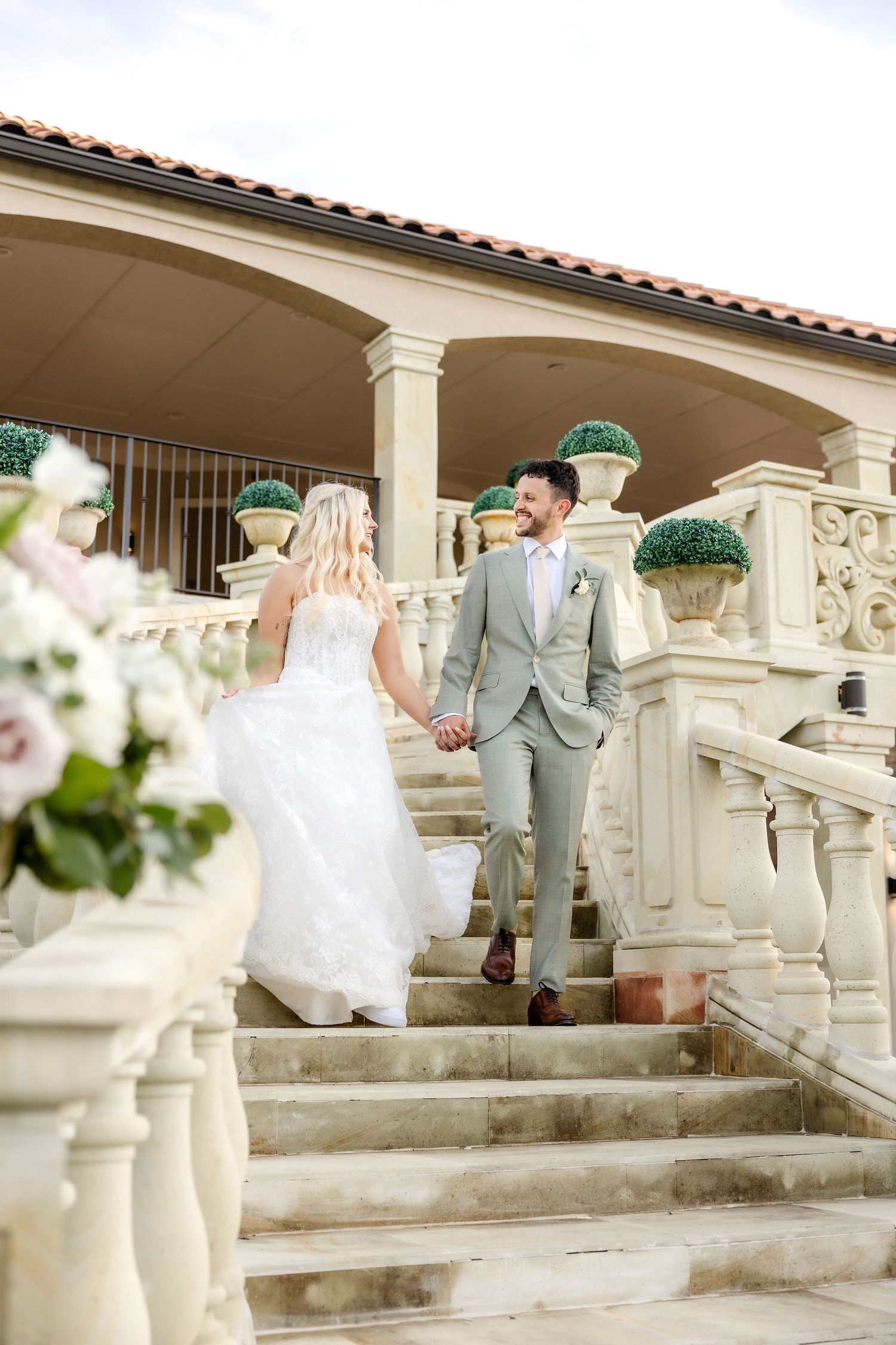 Bride and groom walking down grand staircase at D'Vine Grace Vineyard wedding venue
