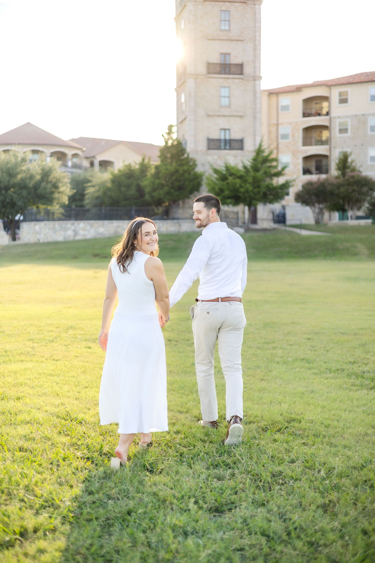 Engaged couple walking away hand in hand at Adriatica Village engagement session