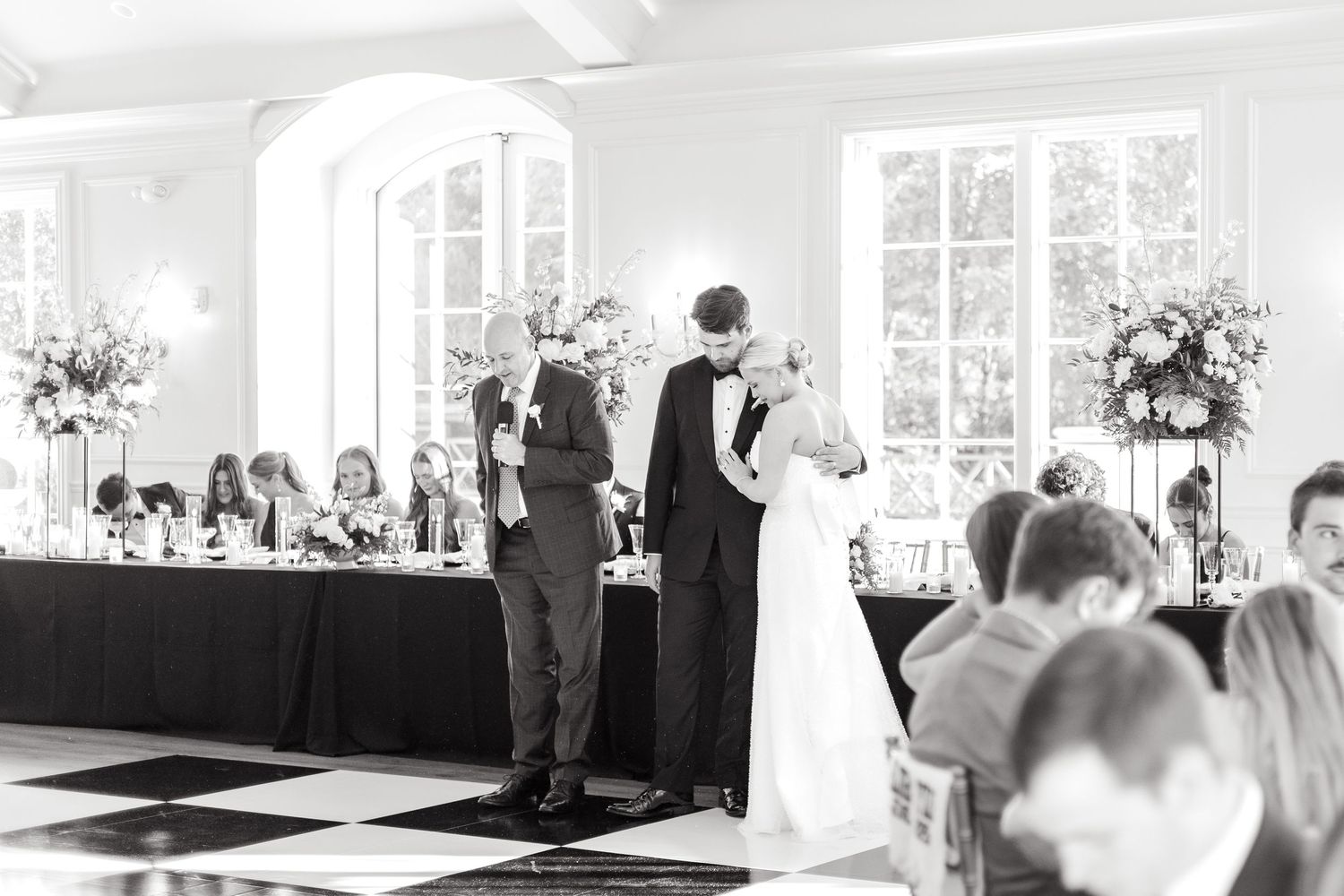 Bride and groom bowing their heads as the prayer and blessing is said over the food at Dallas wedding reception