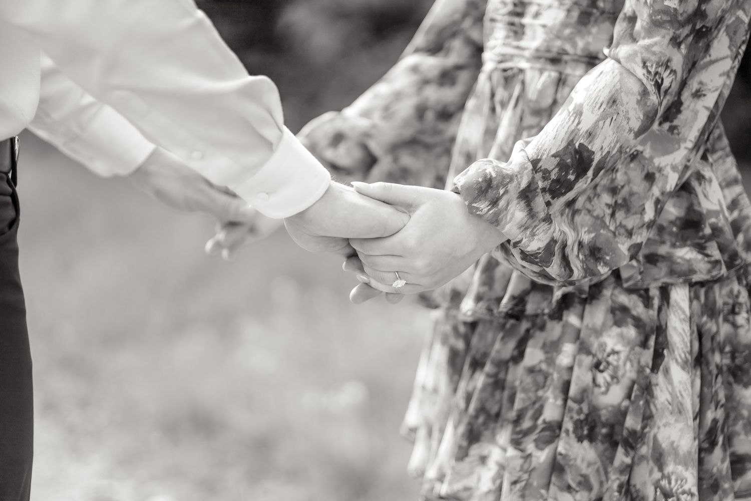 black and white image of engaged couple holding hands at their engagement session at Arbor Hills Nature Preserve