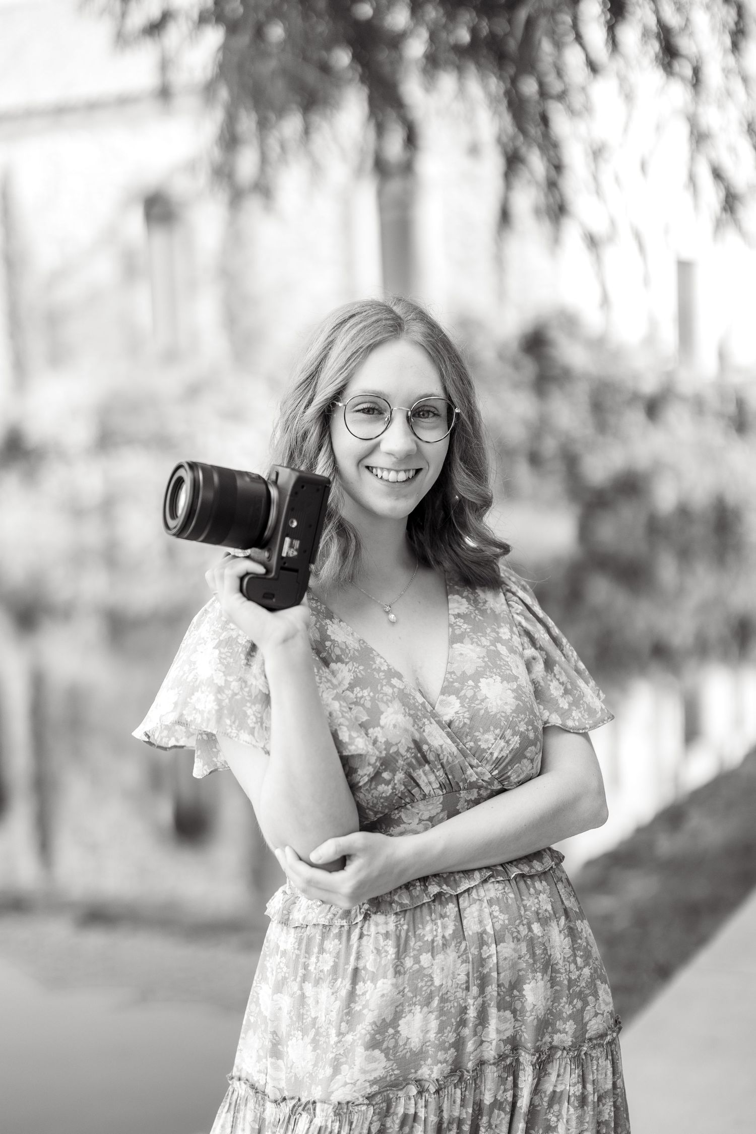 Wedding photographer smiling with a camera in hand