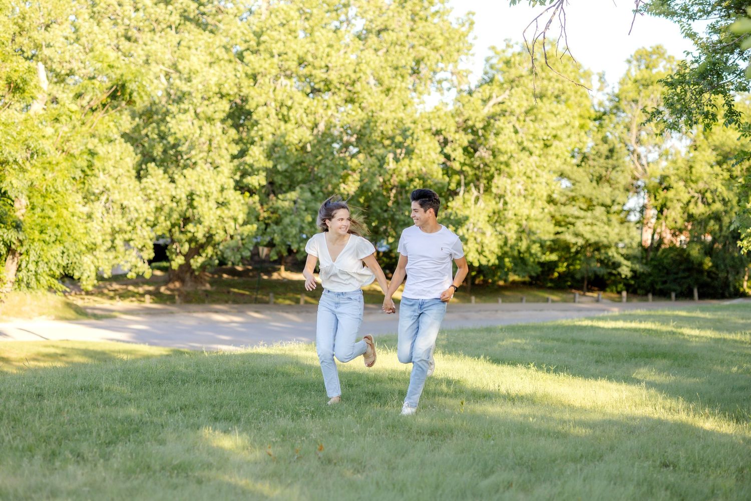 Engaged couple running together at White Rock Lake in Dallas, Texas during engagement photo session with Jayme Jones Photography