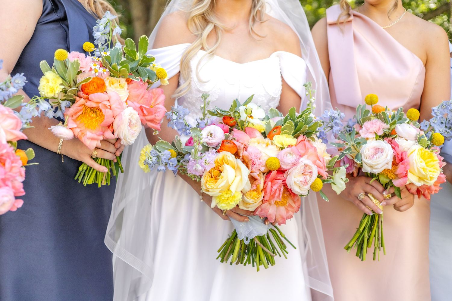 Bride and bridesmaids holding their wedding bouquets during bridal portraits on Dallas wedding day