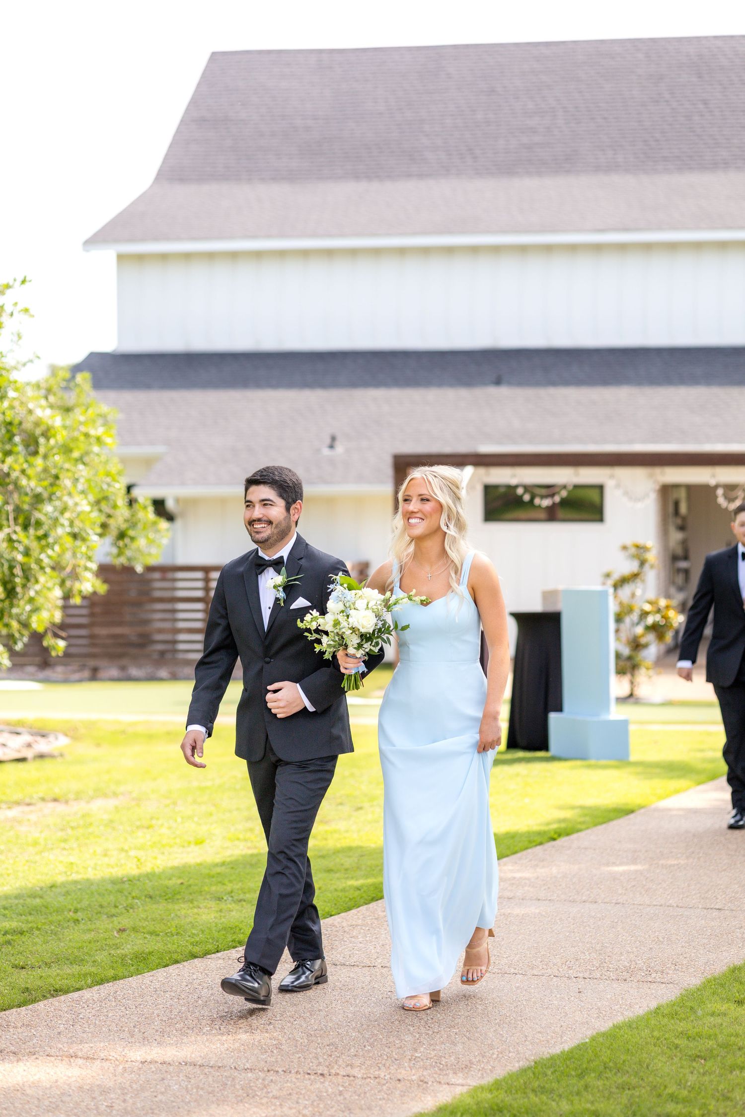 Groomsman and bridesmaid walking into the wedding ceremony together at Dallas wedding