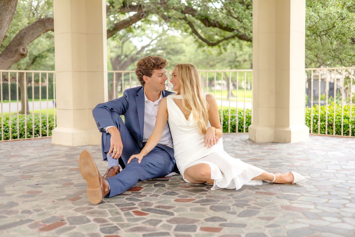 Engaged couple sits close together under the gazebo at Flippen Park, sharing a joyful and intimate moment during their session.