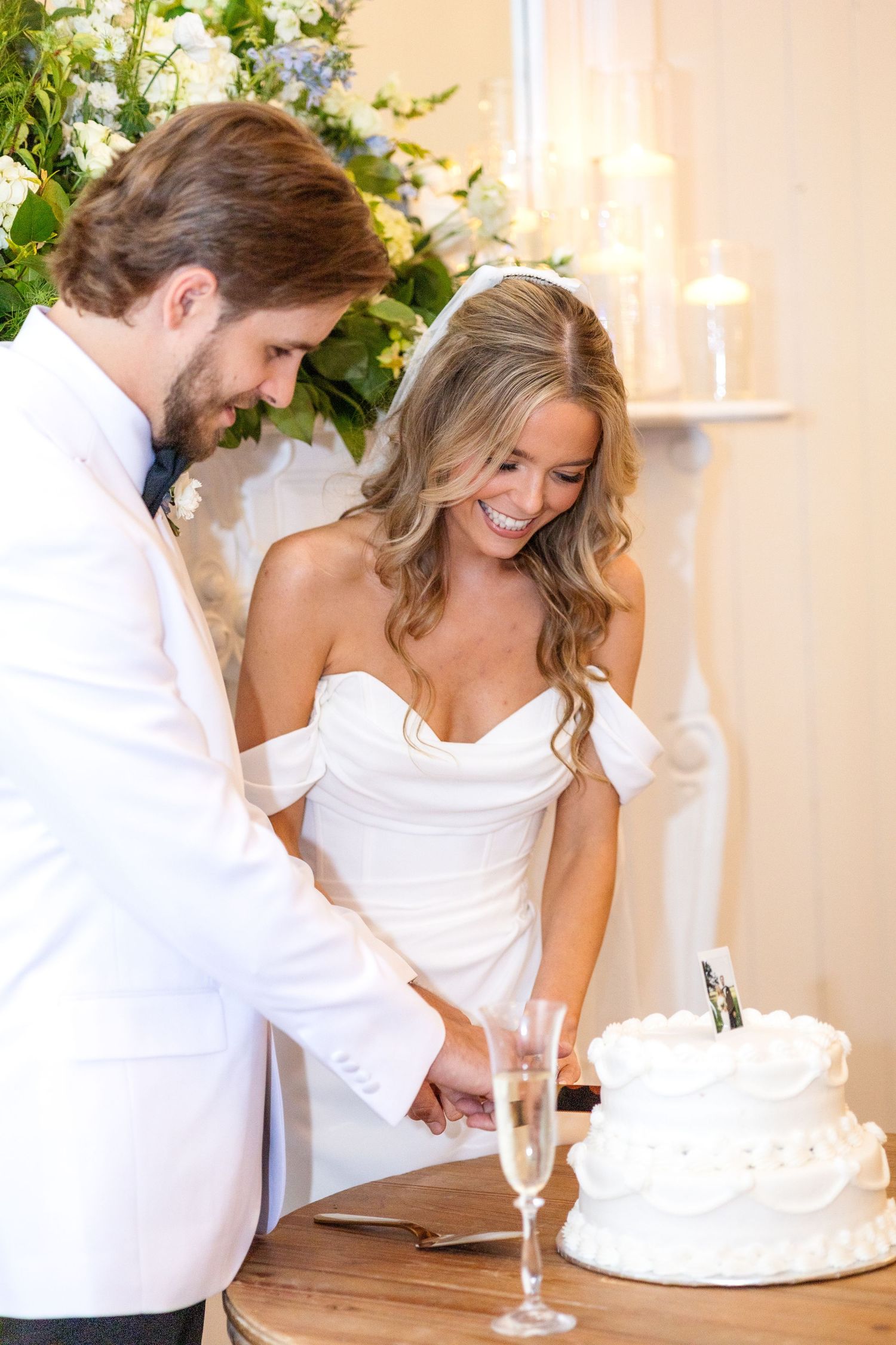 Bride and groom cutting their white wedding cake at Dallas wedding reception