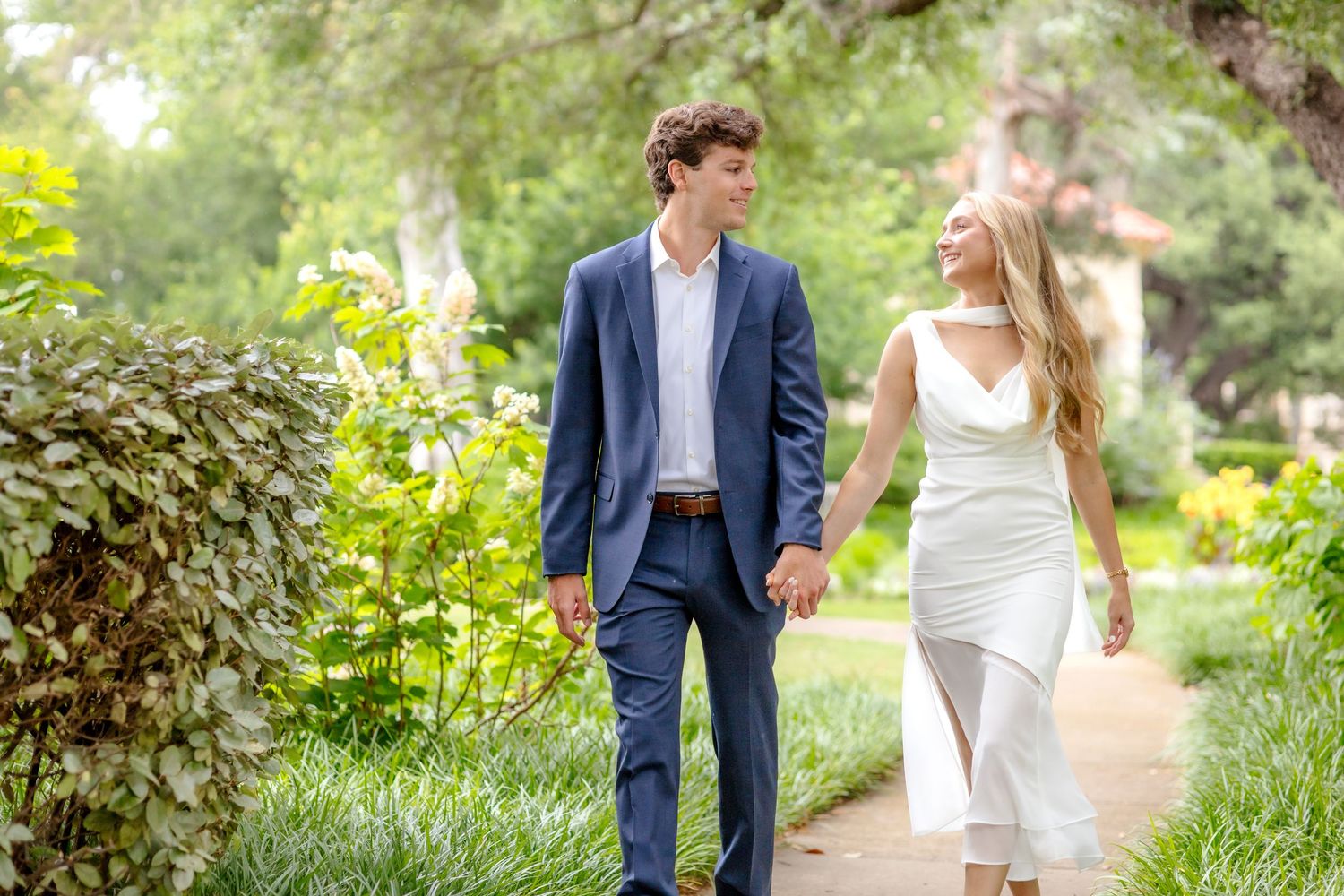 Joyful engaged couple walking hand-in-hand at Flippen Park during their luxury engagement session in Dallas, TX