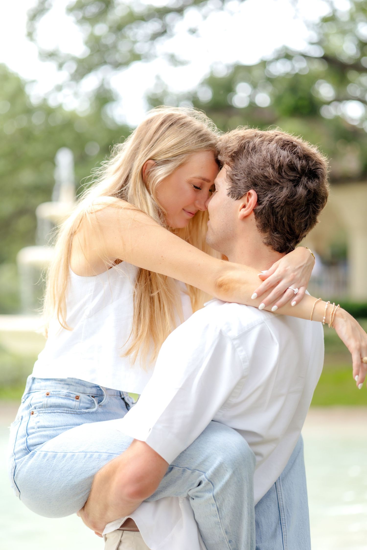 Engaged couple romantically closing their eyes and resting their heads together at Flippen Park in Dallas, Texas at engagement photo session
