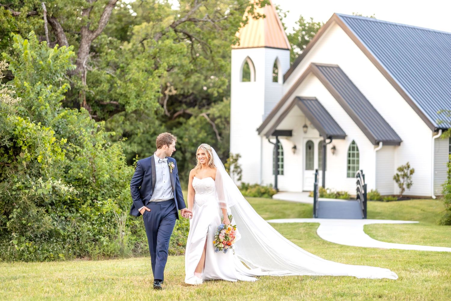 Bride and groom walking hand-in-hand away from the wedding chapel during golden hour at The Barn at Paradise Place in Dallas