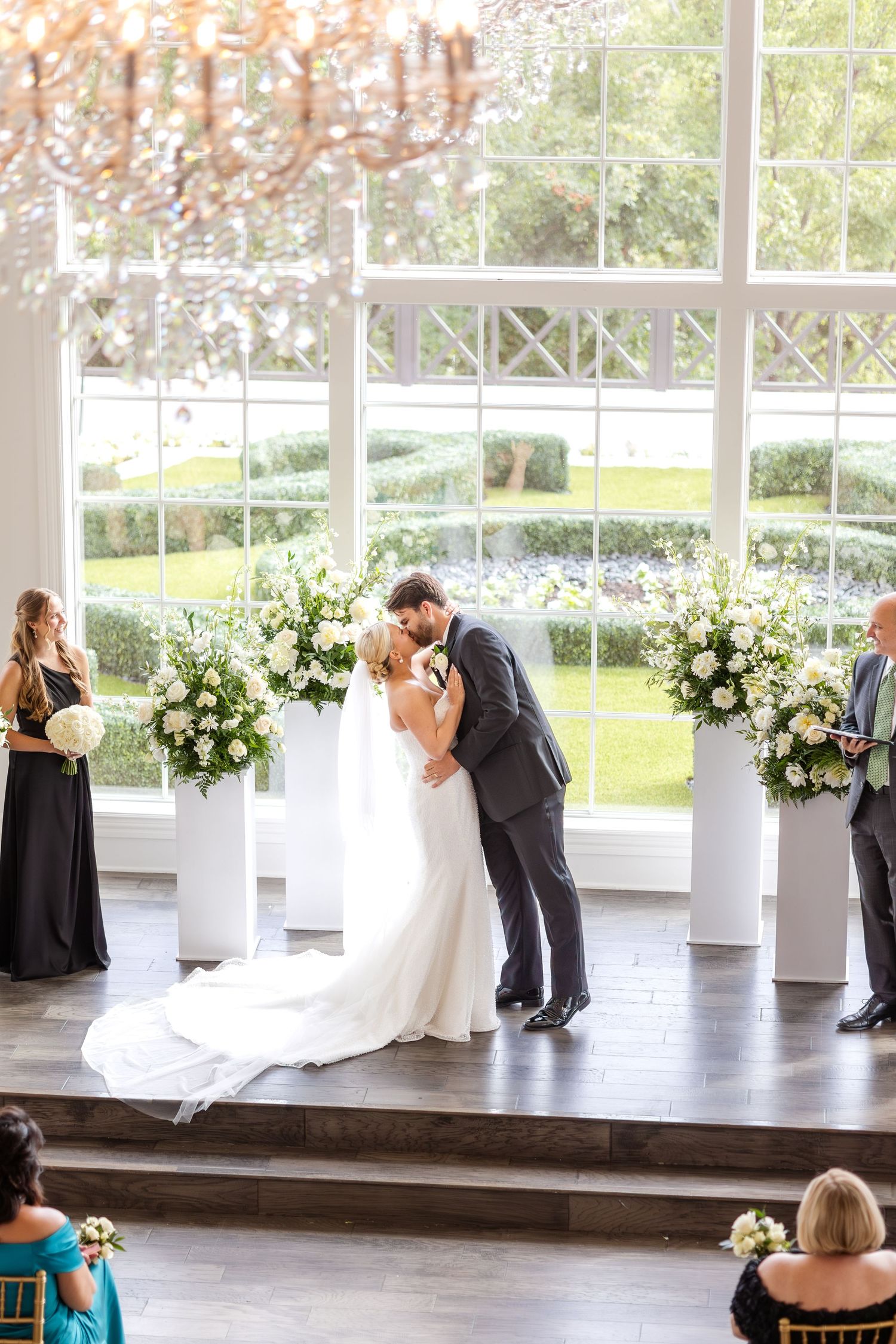 Bride and groom's first kiss during high-end wedding ceremony at The Hillside Estate in Dallas, Texas on beautiful wedding day