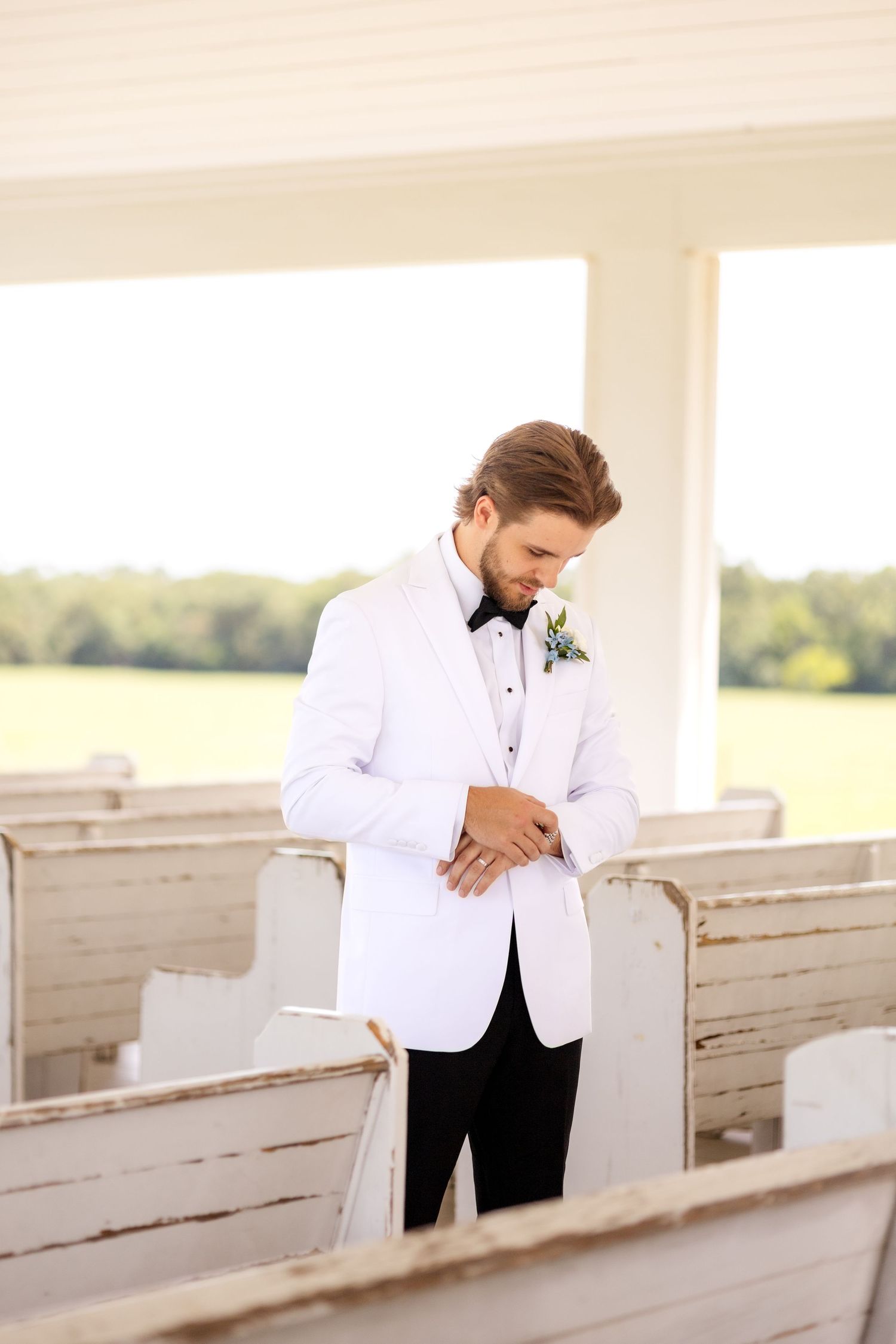 Groom adjusting his watch inside a Dallas wedding chapel on the morning of his wedding