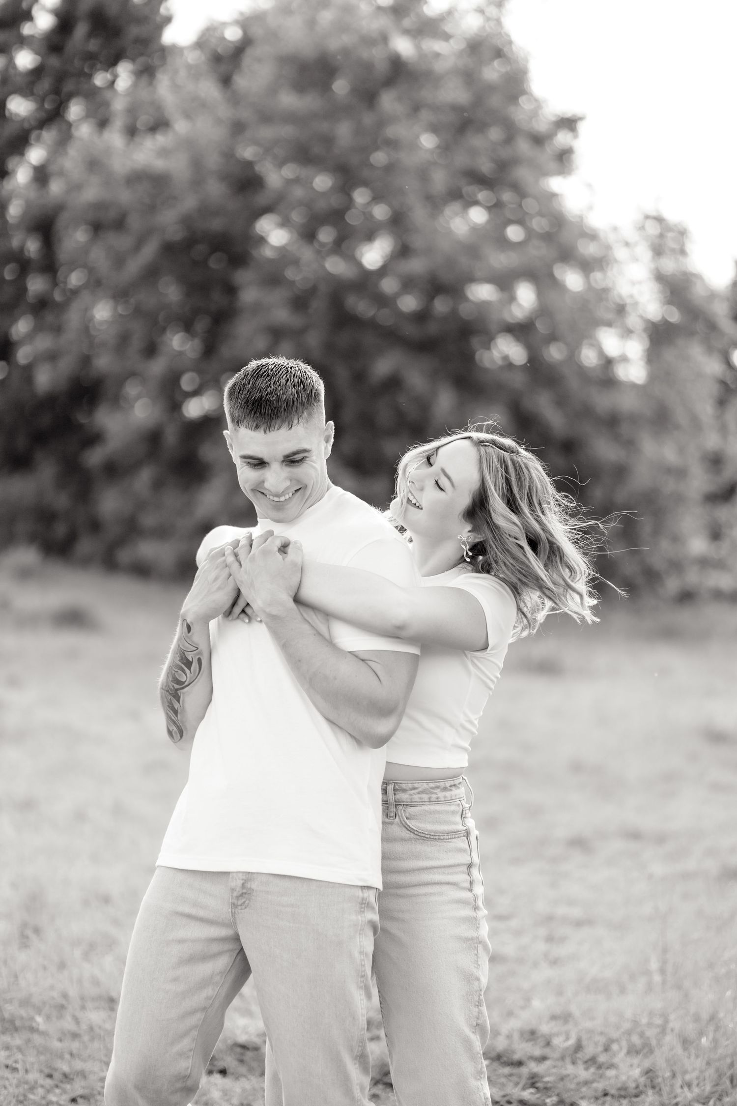 engaged couple hugging in a field in Dallas, Texas